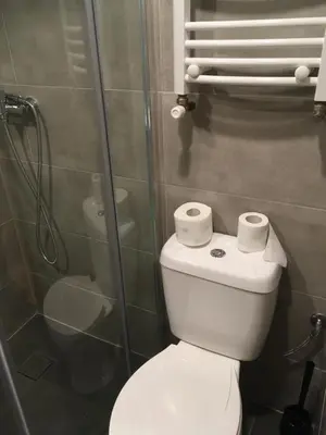 a bathroom with a toilet and a glass shower at Pure Apartments in Kraków