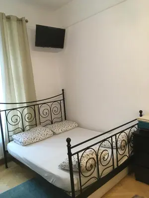 a bedroom with a bed with white sheets and a television at Pure Apartments in Kraków