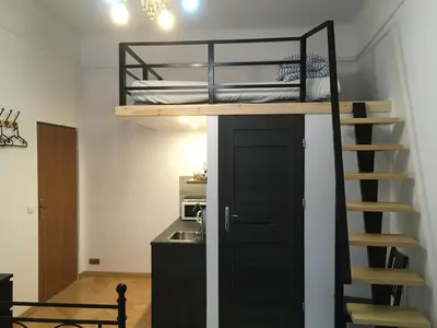 a room with a bunk bed and a staircase at Pure Apartments in Kraków
