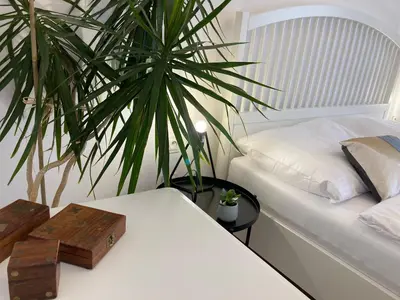 a bedroom with a white bed and a plant at Duo 2 Debniki Modern Apartment near Old Town Fast Wi-Fi Self Check-in in Kraków