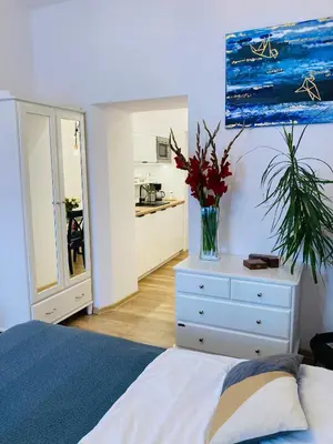 a bedroom with a bed and a vase of flowers on a dresser at Duo 2 Debniki Modern Apartment near Old Town Fast Wi-Fi Self Check-in in Kraków