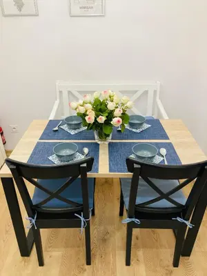 a table with two chairs and a vase of flowers at Duo 2 Debniki Modern Apartment near Old Town Fast Wi-Fi Self Check-in in Kraków