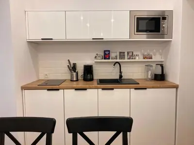 a kitchen with a counter with a microwave and two chairs at Duo 2 Debniki Modern Apartment near Old Town Fast Wi-Fi Self Check-in in Kraków