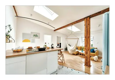 a kitchen with white cabinets and a living room at Sunny Apartment at the Heart of Old Town in Kraków