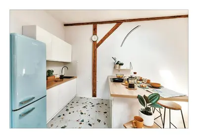 a kitchen with a blue refrigerator and a table at Sunny Apartment at the Heart of Old Town in Kraków
