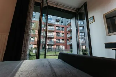 a bedroom with a large window in a building at Garden Old Town with Free Parking and Garden in Kraków
