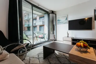 a living room with a table and a large window at Garden Old Town with Free Parking and Garden in Kraków