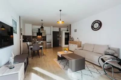 a living room and kitchen with a couch and a table at Garden Old Town with Free Parking and Garden in Kraków
