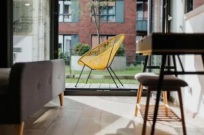 a yellow chair sitting in front of a window at Garden Old Town with Free Parking and Garden in Kraków