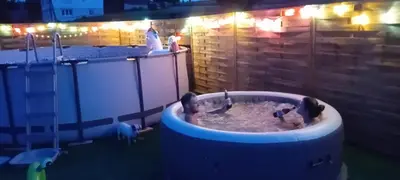 a hot tub with two people in it at night at amel orawa in Podwilk