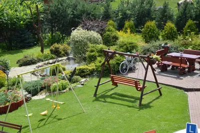 a garden with a bench and a swing at amel orawa in Podwilk
