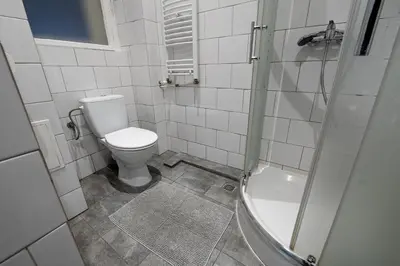 a bathroom with a toilet and a shower at Trzy Kafki Private Rooms in Kraków