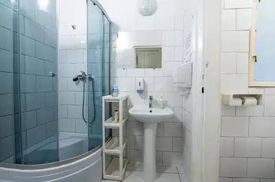 a bathroom with a sink and a shower at Trzy Kafki Private Rooms in Kraków