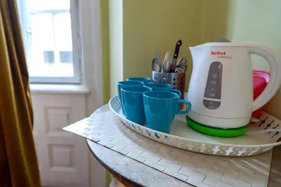 a counter with blue cups and a tea kettle on it at Trzy Kafki Private Rooms in Kraków