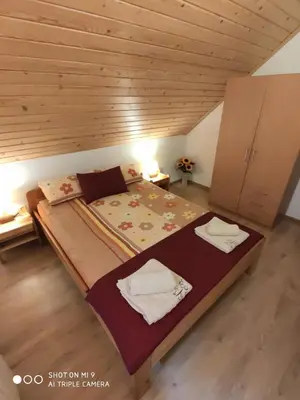 a large bed in a room with a wooden ceiling at Domek u Lucy in Rabka