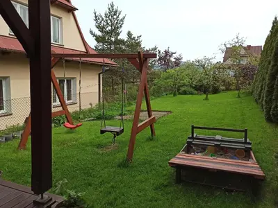 a playground with a swing and a bench in a yard at Domek u Lucy in Rabka