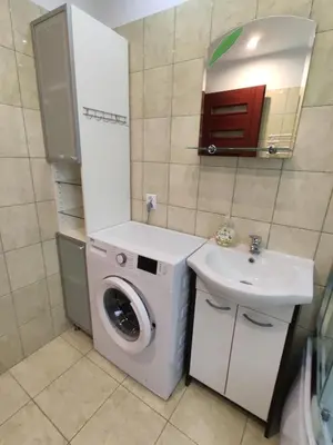 a bathroom with a washing machine and a sink at Domek u Lucy in Rabka