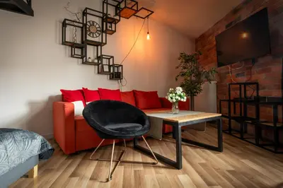 a living room with a red couch and a table at Modern APARTMENT ARIZONA STUDIO OLD TOWN Dietla balcony in Kraków