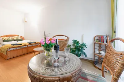 a living room with a table with flowers and wine glasses at Negroni Apartments Stare Miasto in Kraków