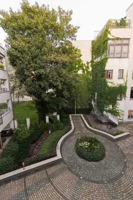 a walkway in a courtyard with a tree and buildings at Negroni Apartments Stare Miasto in Kraków