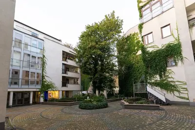 a courtyard in front of two buildings with a tree at Negroni Apartments Stare Miasto in Kraków