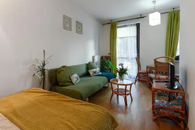 a living room with a green couch and a table at Negroni Apartments Stare Miasto in Kraków