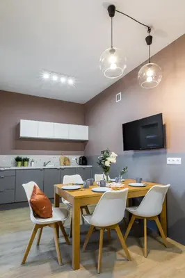 a dining room with a wooden table and white chairs at Friendhouse Residence in Kraków