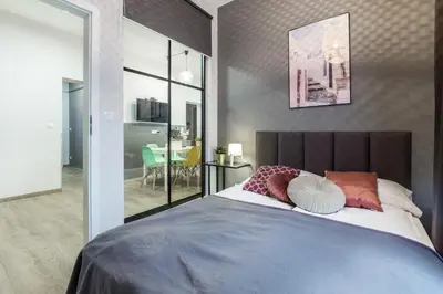 a bedroom with a large bed and a dining room at Friendhouse Residence in Kraków