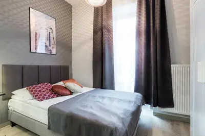 a bedroom with a bed with red pillows on it at Friendhouse Residence in Kraków