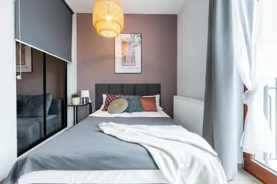 a bedroom with a large bed and a chandelier at Friendhouse Residence in Kraków