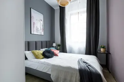 a bedroom with a bed with colorful pillows on it at Friendhouse Residence in Kraków