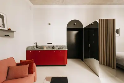 a living room with a red cabinet and a bed at Stylish apartment close to Wawel, Old Town Studio, Main Sq. 3 min in Kraków