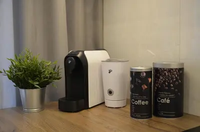 a coffee machine and two cups on a table at MyFive Apartments Kraków in Kraków