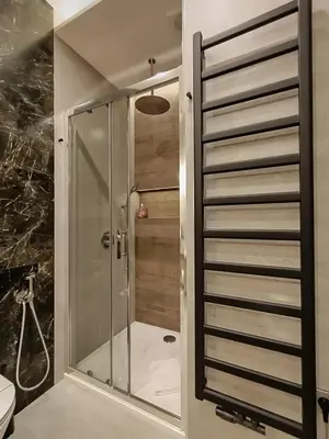 a shower with a glass door in a bathroom at MyFive Apartments Kraków in Kraków