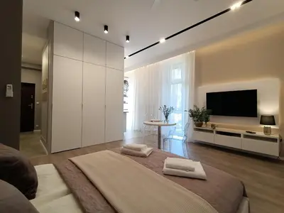 a large bedroom with a large bed and a tv at MyFive Apartments Kraków in Kraków