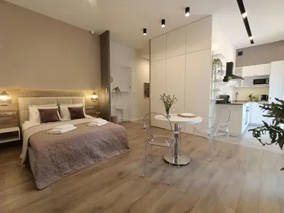 a bedroom with a bed and a table and chairs at MyFive Apartments Kraków in Kraków
