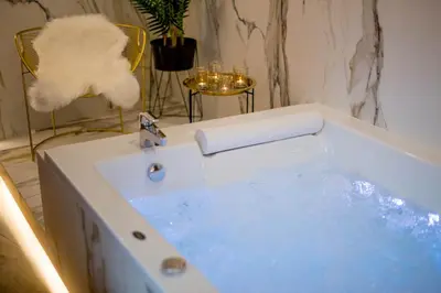 a bath tub filled with blue water in a bathroom at Jacuzzi Apartment Main Square in Kraków