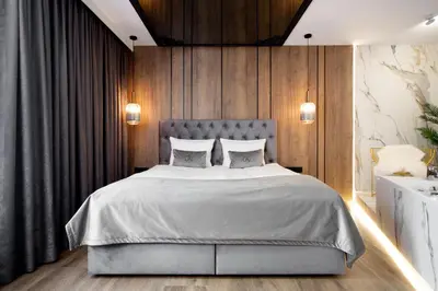 a bedroom with a large bed with wooden walls at Jacuzzi Apartment Main Square in Kraków