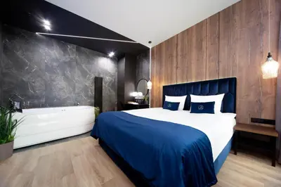 a bedroom with a large bed with a blue blanket at Jacuzzi Apartment Main Square in Kraków