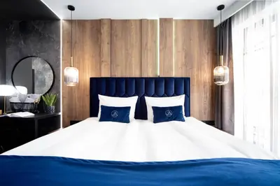 a bedroom with a large bed with blue and white pillows at Jacuzzi Apartment Main Square in Kraków