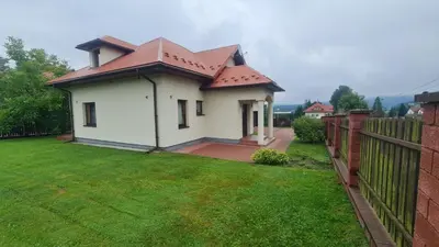 a white house with a red roof on a yard at Cztery Pory Roku in Rabka