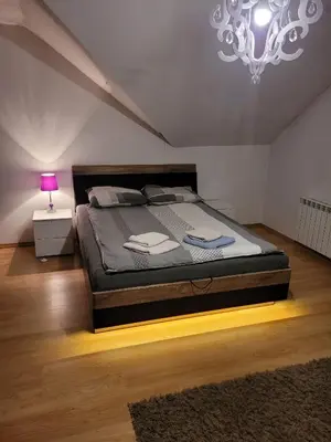 a bedroom with a large bed with a pink lamp at Cztery Pory Roku in Rabka