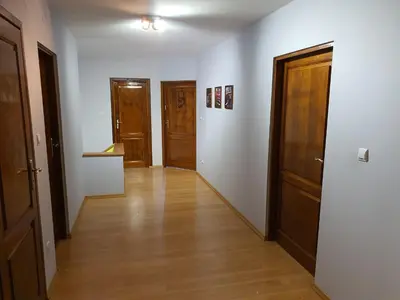 an empty hallway with three doors and wooden floors at Cztery Pory Roku in Rabka