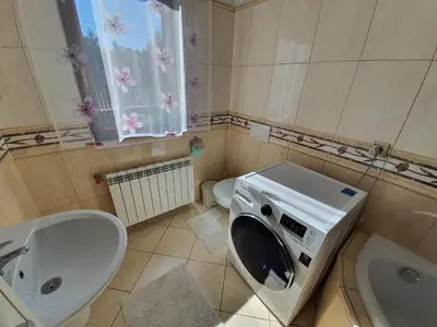 a bathroom with a sink and a washing machine at Cztery Pory Roku in Rabka