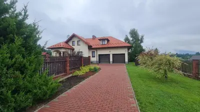 a white house with a red roof and a brick driveway at Cztery Pory Roku in Rabka