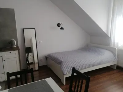 a bedroom with a bed and a mirror and a table at Prokocim Apartments in Kraków