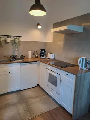 a kitchen with white cabinets and a stove top oven at Prokocim Apartments in Kraków