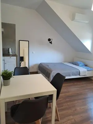 a bedroom with a bed and a table and chairs at Prokocim Apartments in Kraków