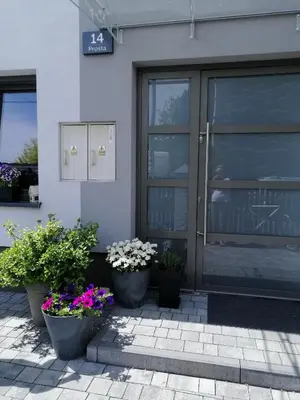 a building with three potted plants in front of a door at Prokocim Apartments in Kraków