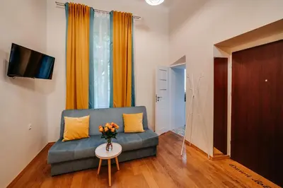 a bottle of wine and a plate of food on a table at ALPARI apartments in Kraków